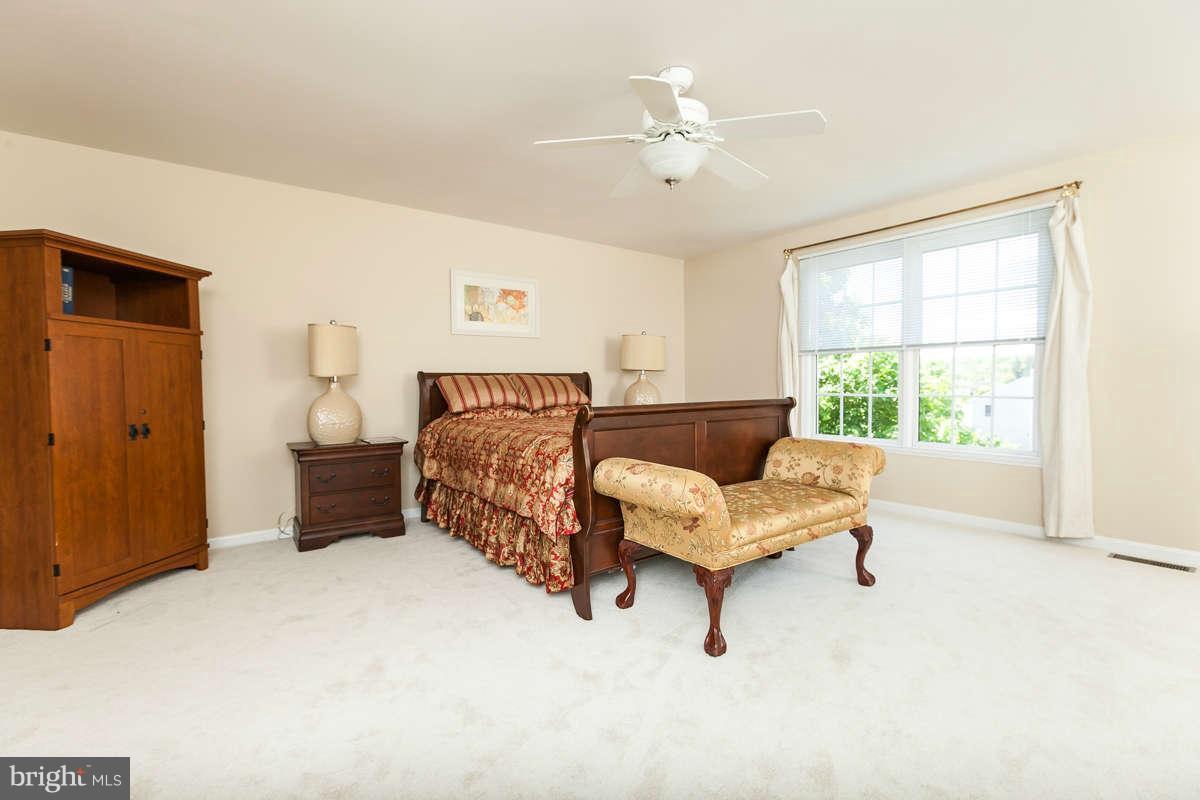 8596 Trail View Drive Ellicott City, MD 21043 - Photo 15 of 29 a bedroom with a bed and a chandelier