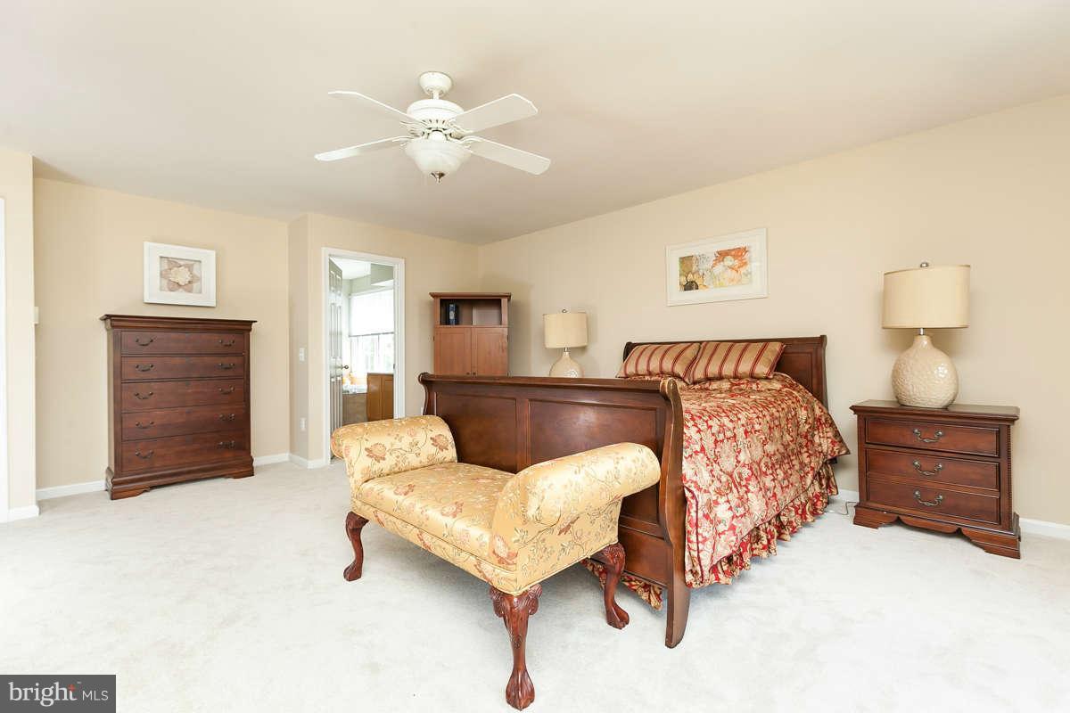 8596 Trail View Drive Ellicott City, MD 21043 - Photo 16 of 29 a bedroom with a bed and ceiling fan