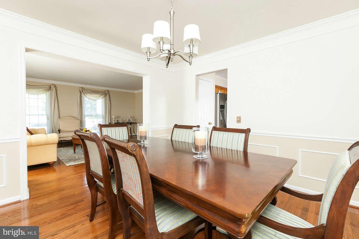 8596 Trail View Drive Ellicott City, MD 21043 - Photo 5 of 29 a dining room with wooden floor a chandelier a wooden table and chairs