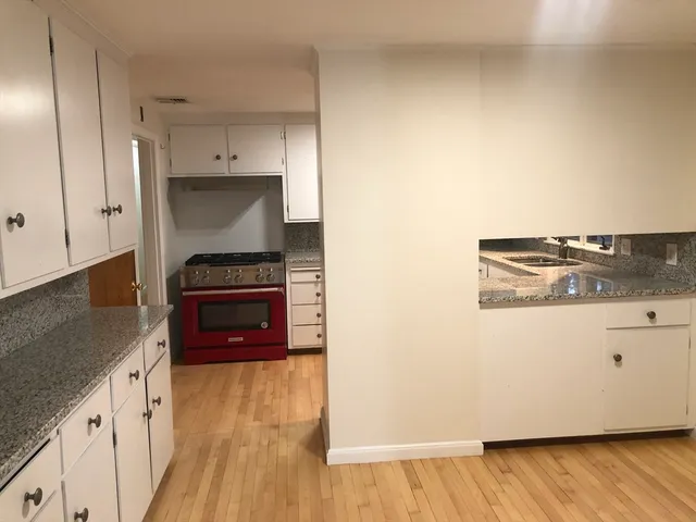 a kitchen with white cabinets and white appliances