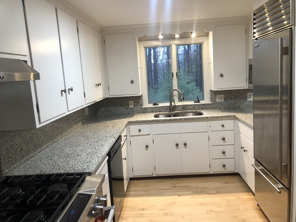 53 Deerhaven Road, Unit 1 Lincoln, MA 01773 - Photo 22 of 42 a bathroom with a granite countertop sink and a mirror