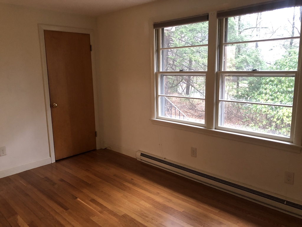 53 Deerhaven Road, Unit 1 Lincoln, MA 01773 - Photo 27 of 42 an empty room with wooden floor and windows