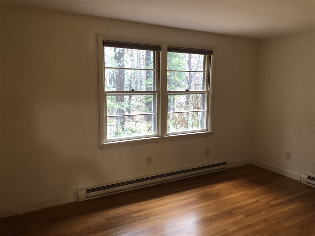 53 Deerhaven Road, Unit 1 Lincoln, MA 01773 - Photo 28 of 42 an empty room with wooden floor and windows