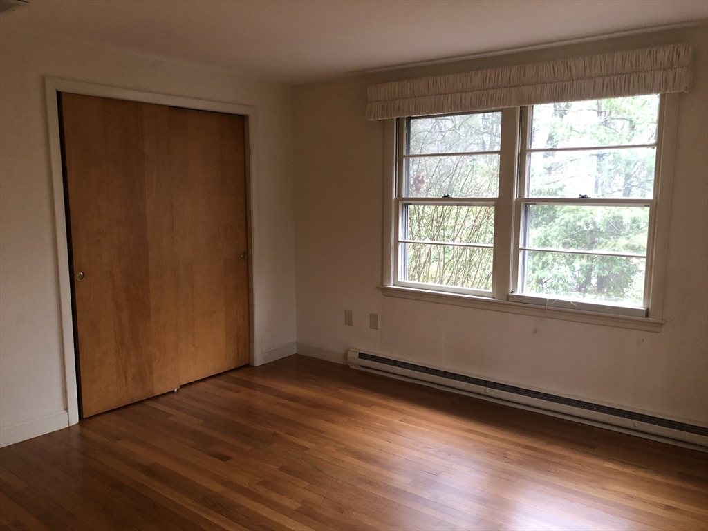 53 Deerhaven Road, Unit 1 Lincoln, MA 01773 - Photo 29 of 42 an empty room with wooden floor and windows