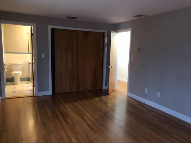 a bathroom with a granite countertop toilet sink and mirror