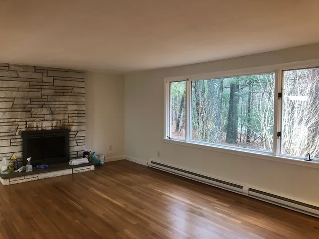 an empty room with wooden floor and fireplace