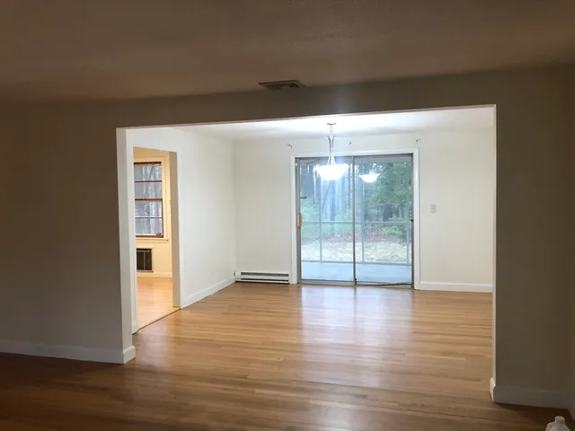 a view of a room with wooden floor and window
