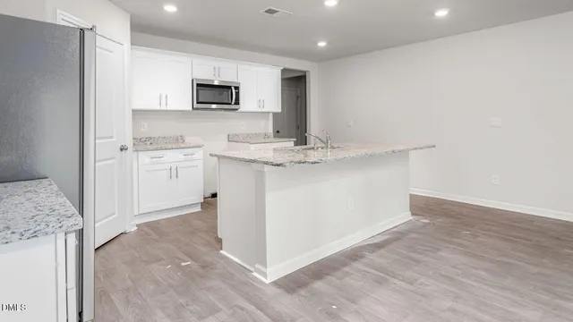 a kitchen with stainless steel appliances granite countertop a stove a sink and a refrigerator