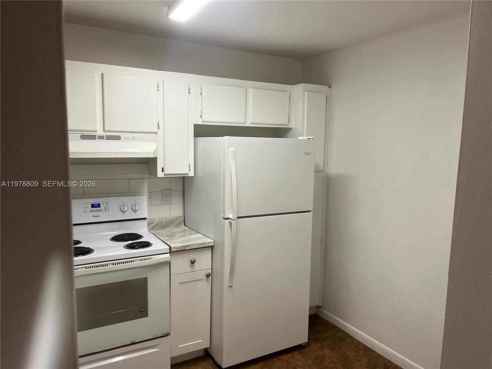 1250 Lincoln Road, Unit 310 Miami Beach, FL 33139 - Photo 12 of 27 a white refrigerator freezer and a stove sitting inside of a kitchen