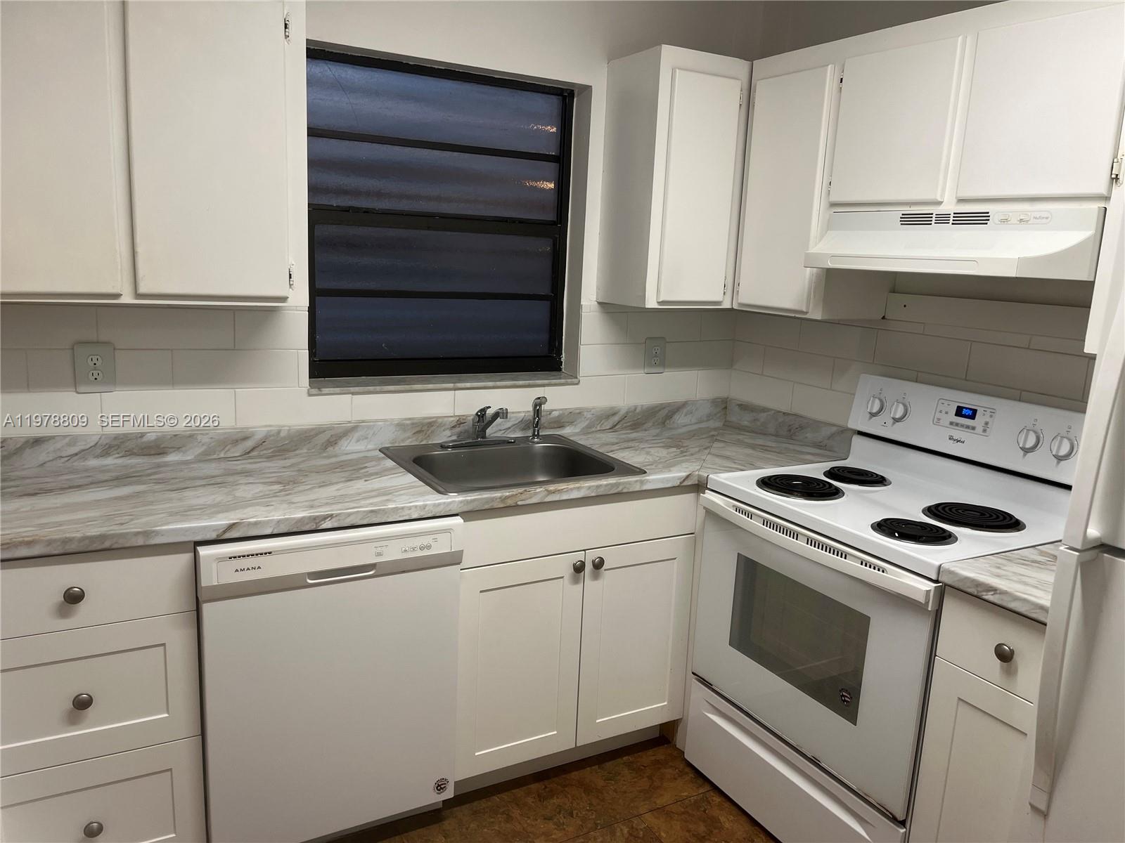 1250 Lincoln Road, Unit 310 Miami Beach, FL 33139 - Photo 13 of 27 a kitchen with granite countertop white cabinets and white appliances