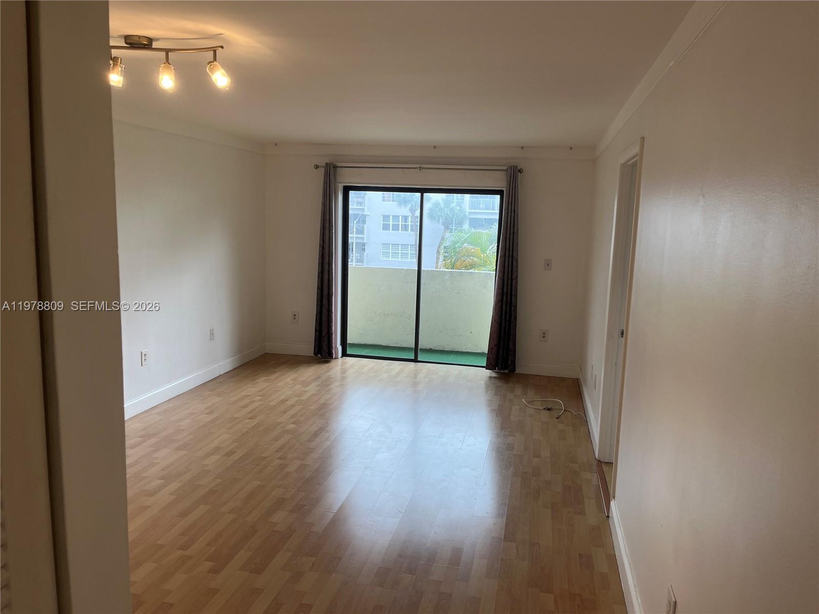 1250 Lincoln Road, Unit 310 Miami Beach, FL 33139 - Photo 9 of 27 an empty room with wooden floor and windows