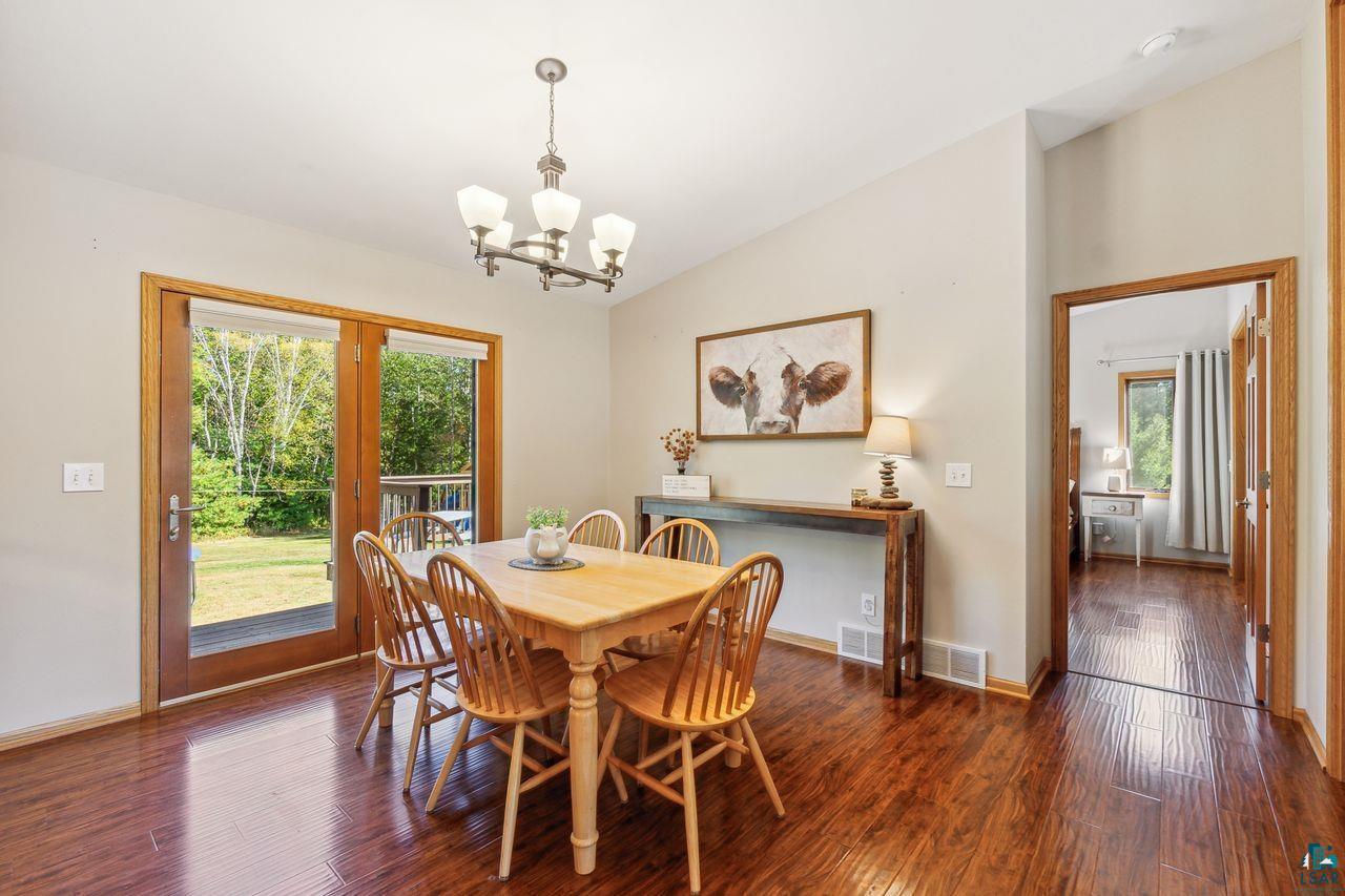 74050 Bjork Road Washburn, WI 54891 - Photo 8 of 33 Dining space with an inviting chandelier, lofted ceiling, dark hardwood / wood-style flooring, and a wealth of natural light