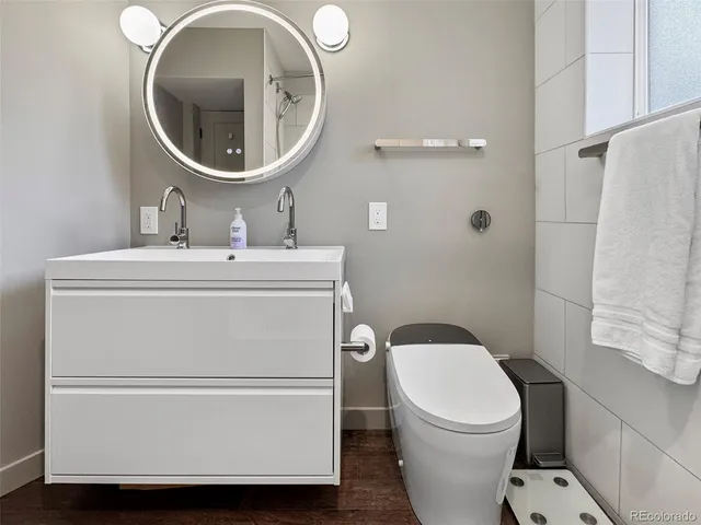 a bathroom with a sink a toilet and a mirror