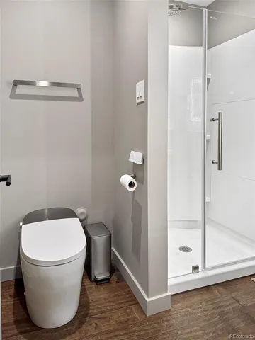 a bathroom with a toilet and a glass shower door