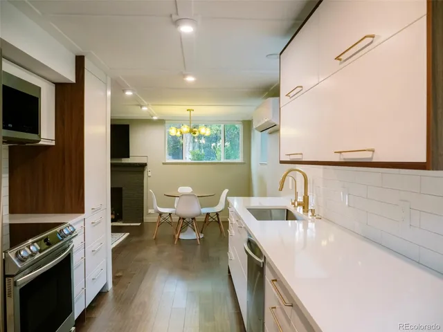 a kitchen with kitchen island a sink appliances and a counter top space