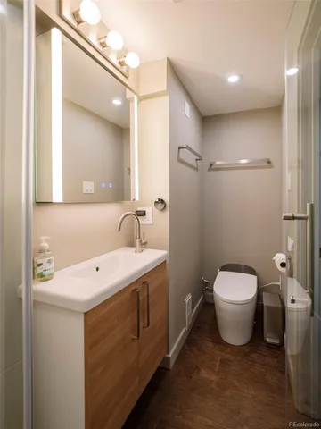 a bathroom with a toilet sink and mirror