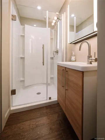 a bathroom with a shower sink and mirror