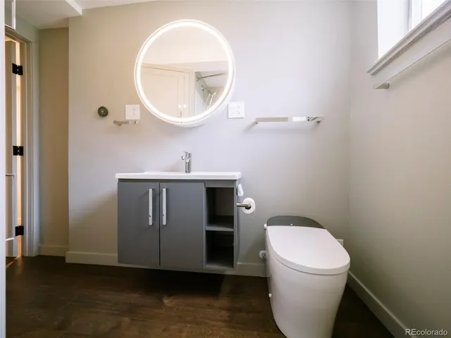a bathroom with a toilet a sink and mirror