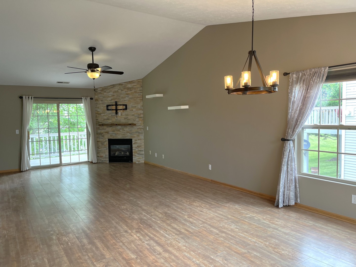957 Arvle Circle, Unit 957 Sycamore, IL 60178 - Photo 3 of 17 an empty room with wooden floor fireplace and windows