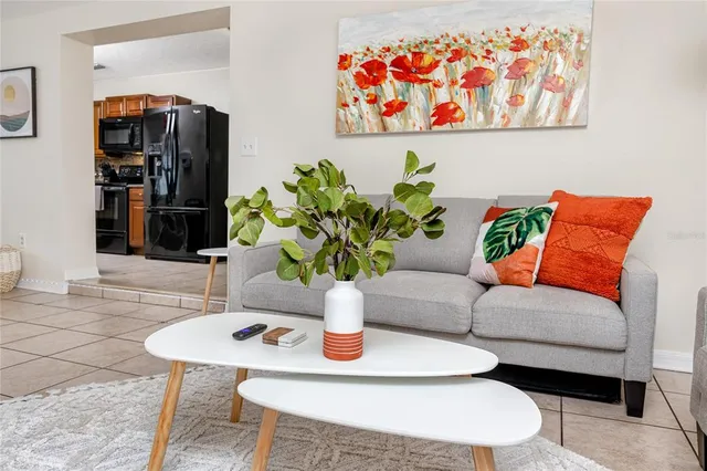 a living room with furniture potted plant and wooden floor