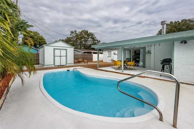 a swimming pool with outdoor seating and yard