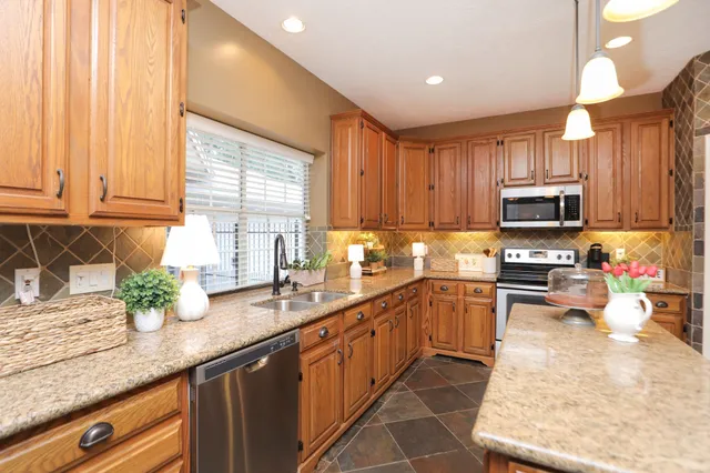 a kitchen with granite countertop a stove sink and microwave