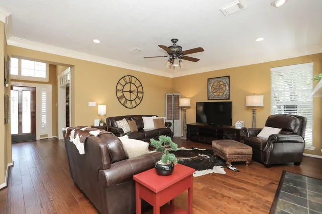 a living room with furniture a large window and a flat screen tv