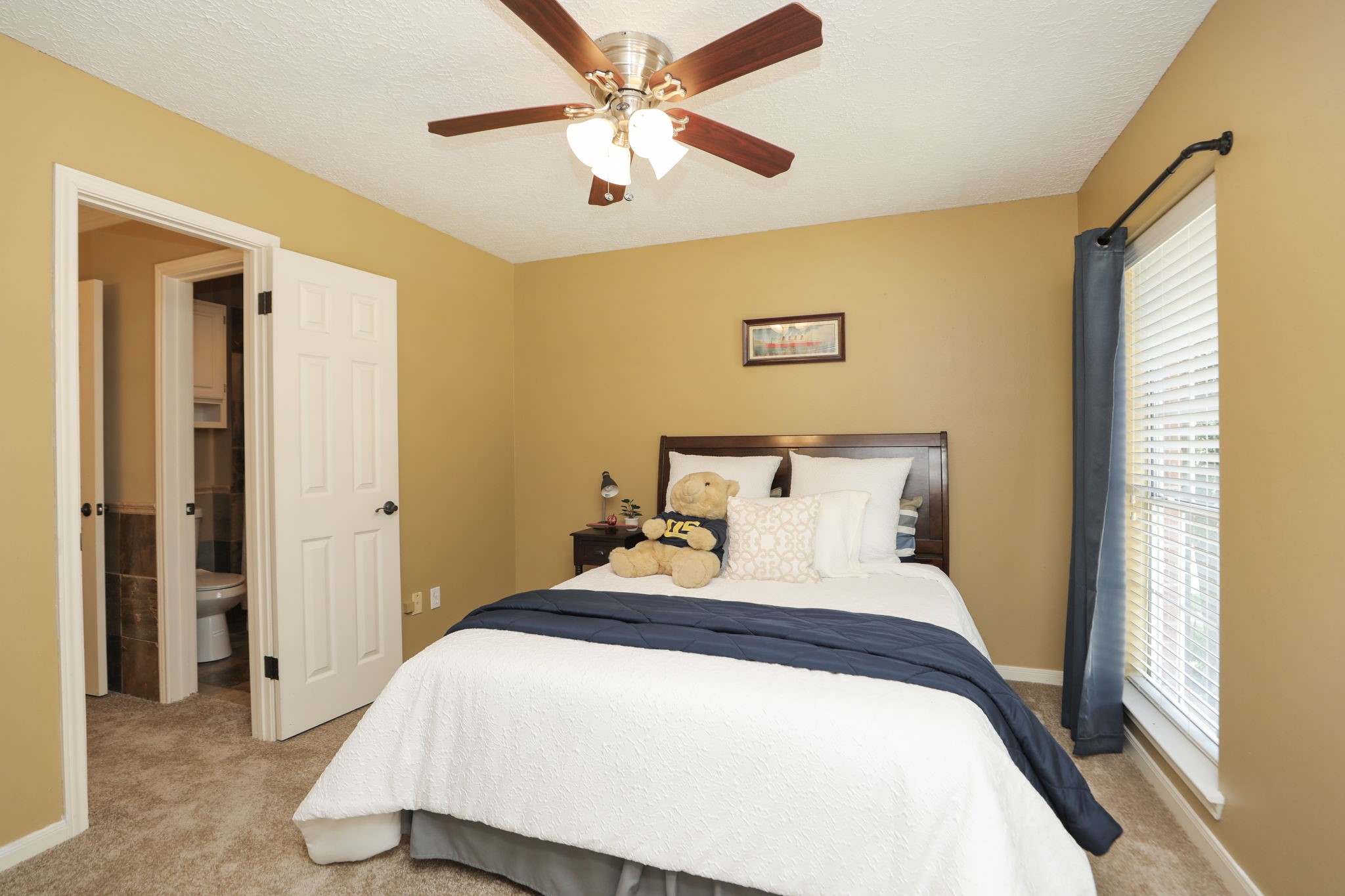 427 West North Hill Drive Spring, TX 77388 - Photo 30 of 41 a bedroom with a large bed and a chandelier