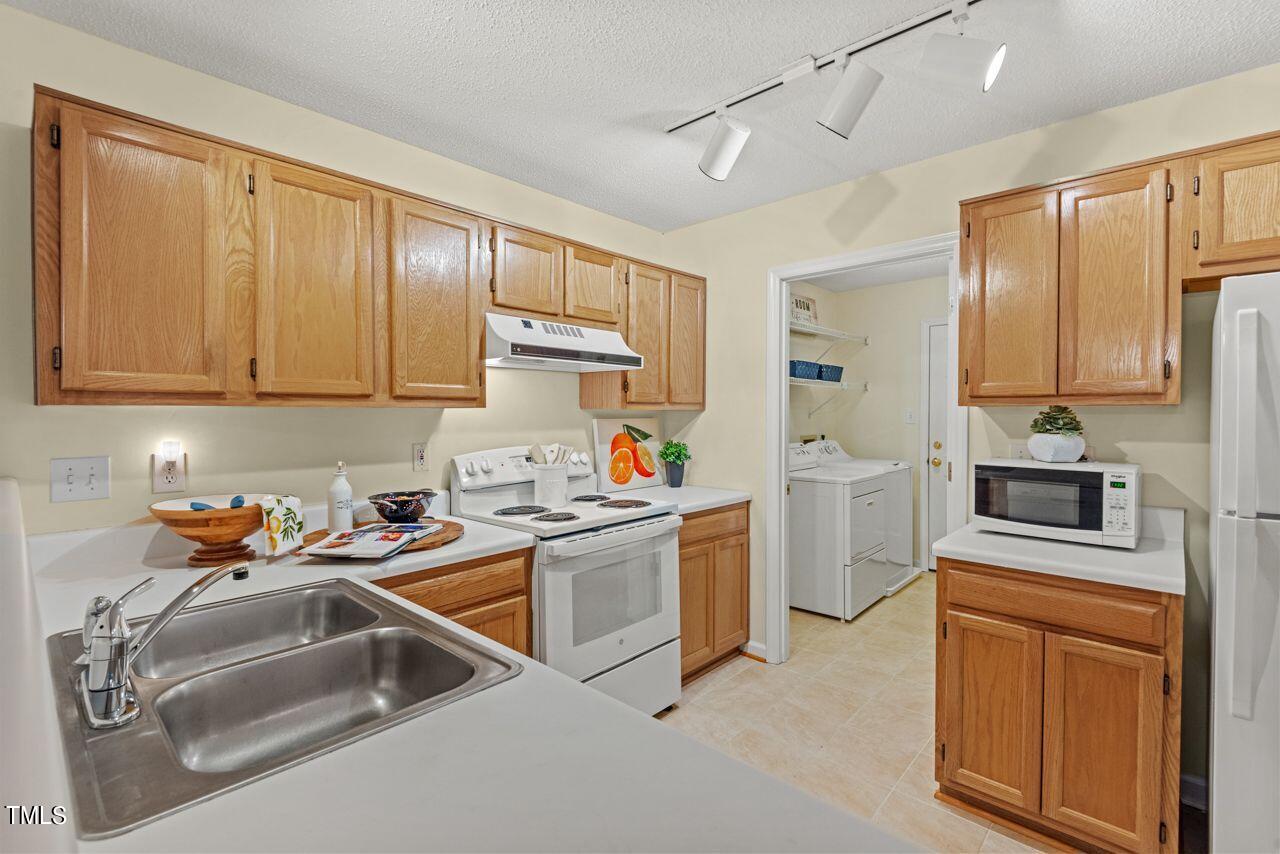 3100 Wilderness Road Durham, NC 27712 - Photo 16 of 35 a kitchen that has a sink cabinets counter space and appliances
