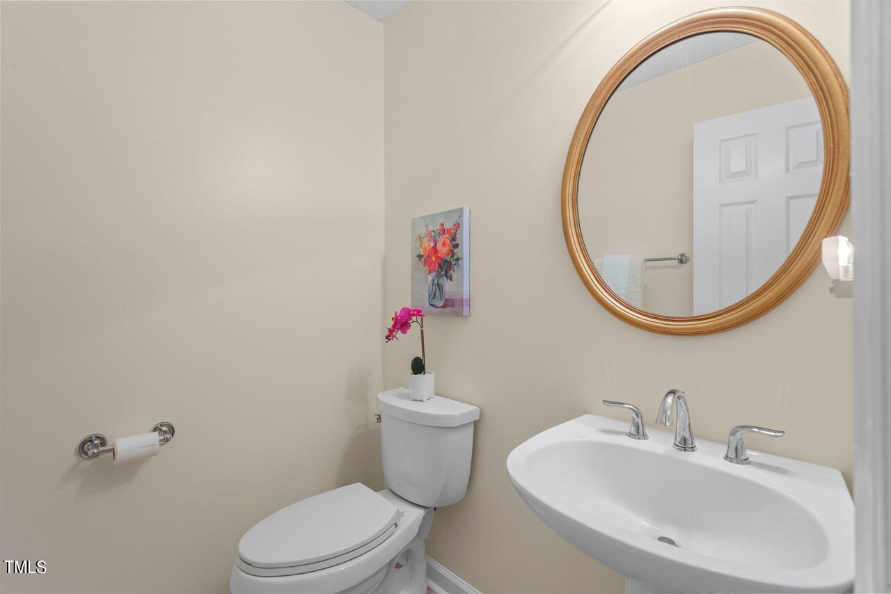 3100 Wilderness Road Durham, NC 27712 - Photo 20 of 35 a bathroom with a sink a mirror and a toilet