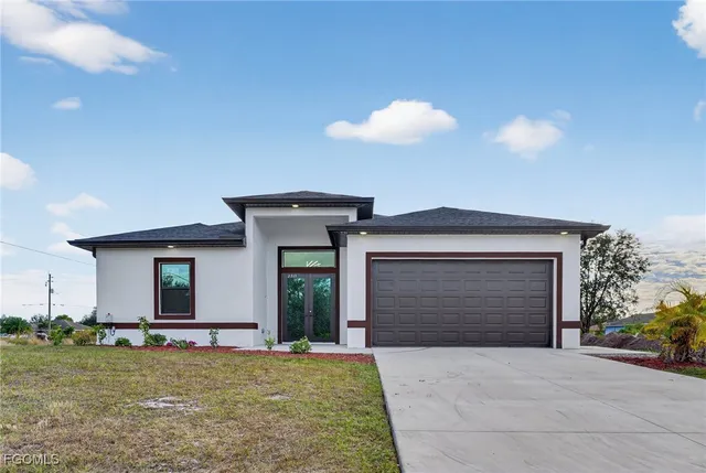 a front view of a house with a yard and garage