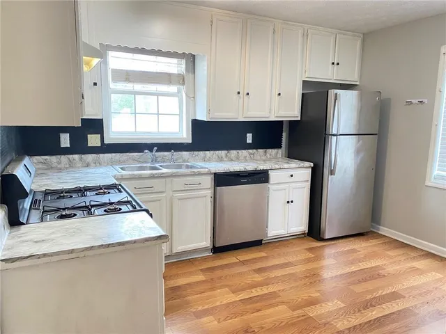a kitchen with a stove a sink and a refrigerator