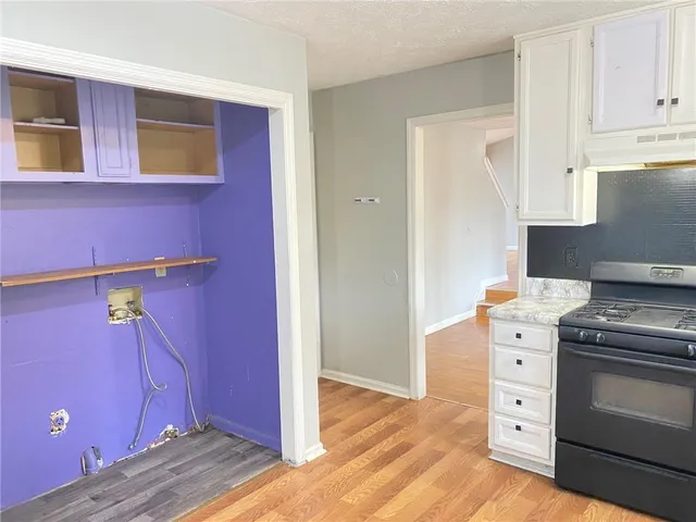 a kitchen with cabinets appliances and wooden floor