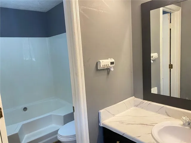 a bathroom with a granite countertop sink toilet and shower