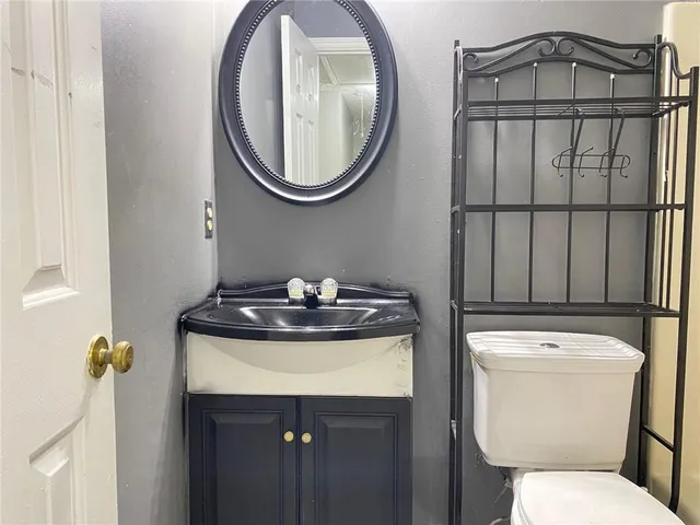 a bathroom with a toilet a sink and a mirror