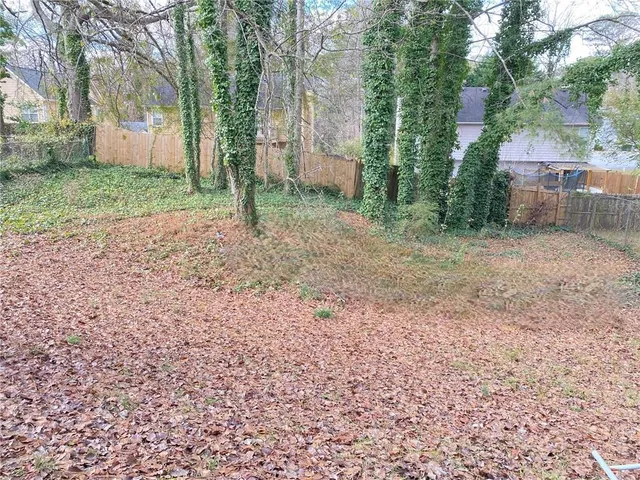a view of a yard with plants and trees