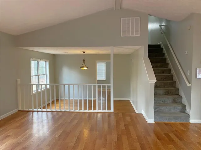 a view of a hallway with wooden floor and staircase
