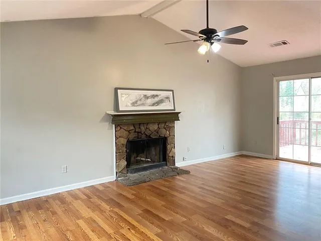 wooden floor fireplace and window in an empty room
