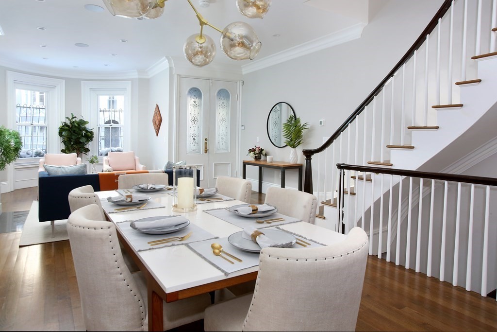 a dining room with wooden floor a glass table and chairs