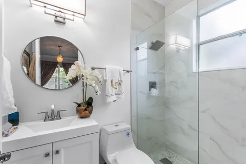 a bathroom with a sink a toilet and a mirror