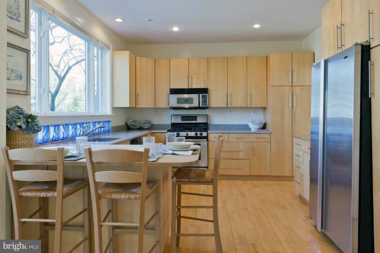3219 Klingle Road Northwest Washington, DC 20008 - Photo 27 of 30 a kitchen with stainless steel appliances granite countertop a stove a refrigerator and a microwave