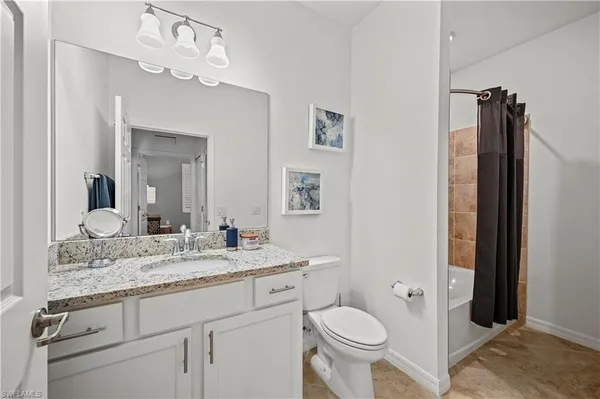 a bathroom with a granite countertop sink toilet and shower