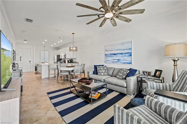 a living room with furniture a flat screen tv and a chandelier
