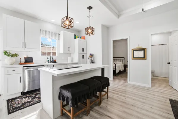 a kitchen with a refrigerator a stove cabinets and wooden floor