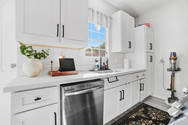 a kitchen with white cabinets and white appliances