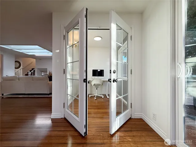 a view of a hallway with wooden floor and staircase