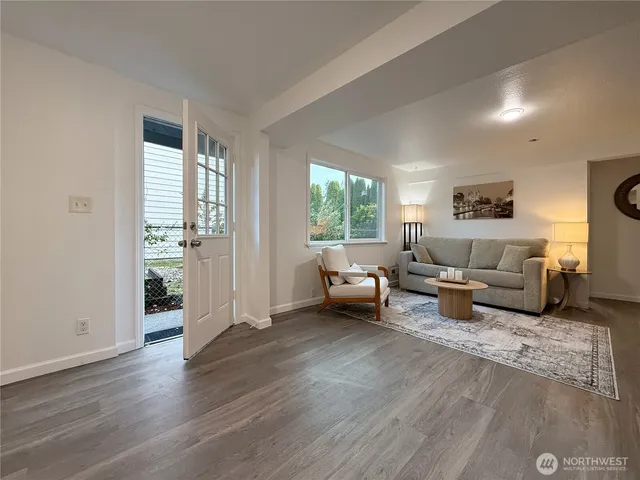 a living room with furniture and a wooden floor
