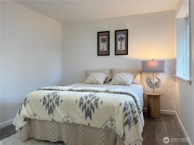 a bedroom with a bed and wooden floor