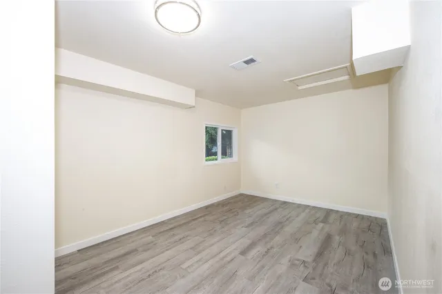 a view of a room with wooden floor and window