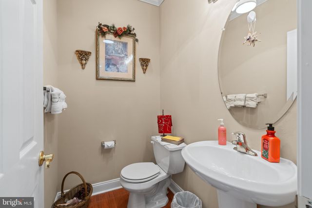 a kitchen with stainless steel appliances granite countertop a refrigerator a sink dishwasher a stove and white countertops with wooden floor